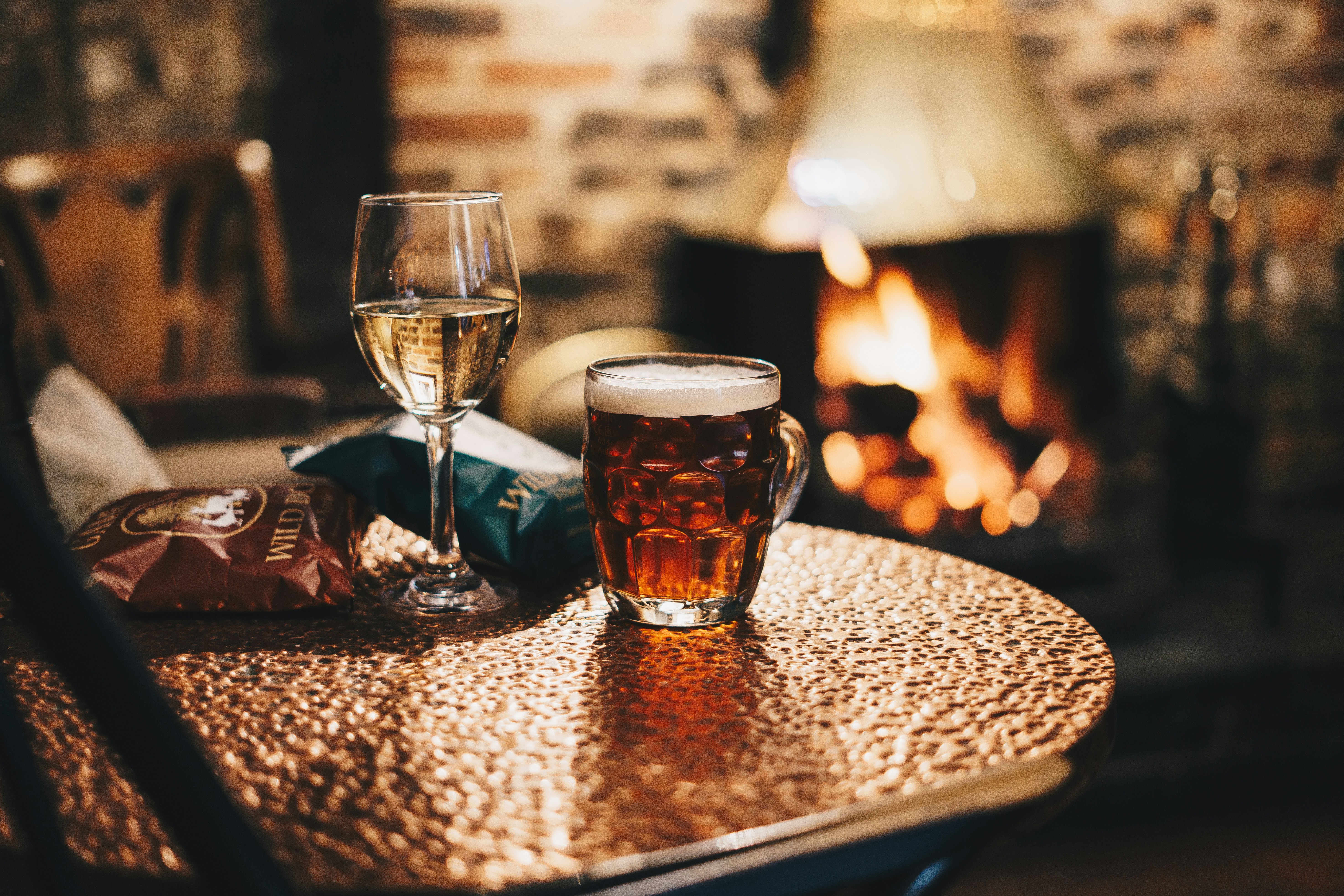Cozy interior of The Duke of Bernay pub with wooden beams, fireplace, and patrons enjoying drinks