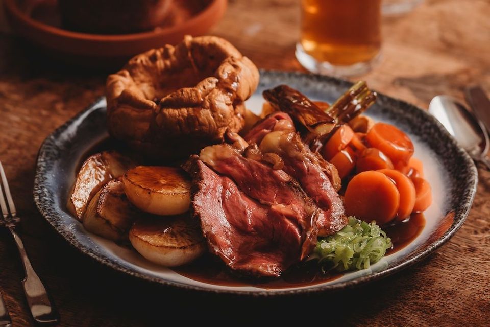Sunday roast dinner with beef, Yorkshire pudding, roasted vegetables and gravy